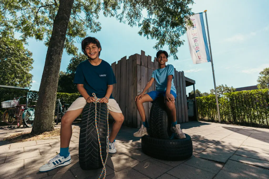 Kinderen spelen buiten op het speelterrein van de buitenschoolse opvang van Vlietkinderen in Leidschenveen Den Haag.