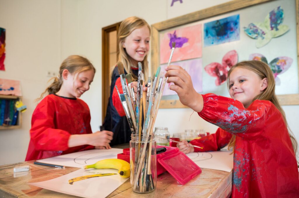 Kinderen schilderen en knutselen tijdens een creatieve activiteit bij BSO Vlietkinderen in Voorburg.