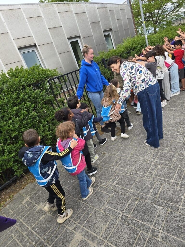 peuter4daagse: De peuters van KC Kompas lopen door de poort van kinderen van de basisschool.
