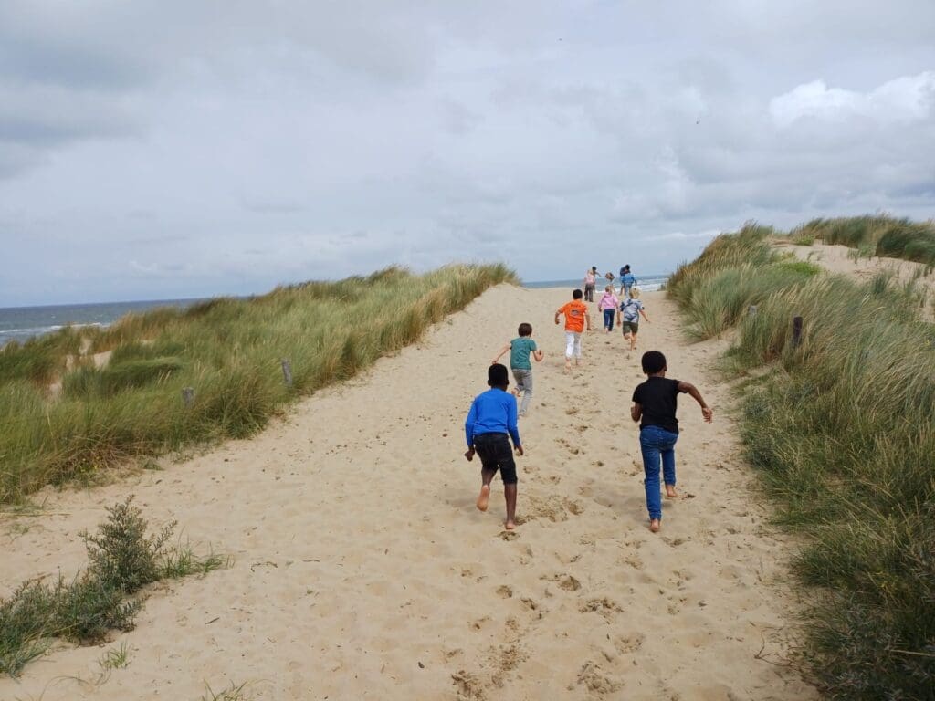 Ga je mee naar zee? - kinderen rennen over de duinen