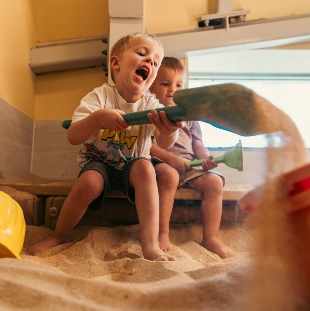 Kinderen ontdekken en spelen met zand bij Vlietkinderen in Leidschendam.